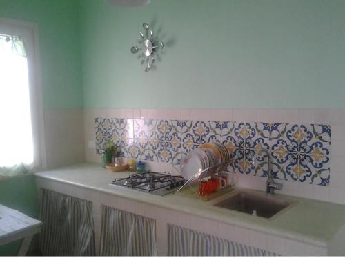 eine Küche mit einer Spüle und einem Herd Top-Backofen in der Unterkunft La casa del vento Stagnone in Marsala