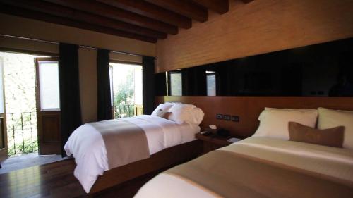 a bedroom with two beds and a window at Hotel Boutique Casa Madero in Morelia