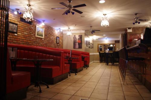 a restaurant with red seats and a brick wall at South Hill Lodge in Prince Albert