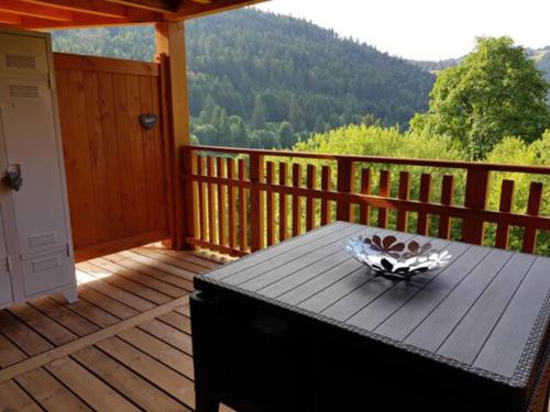 une terrasse en bois avec une table sur une terrasse couverte dans l'établissement Rev2 Montagne, à La Bresse