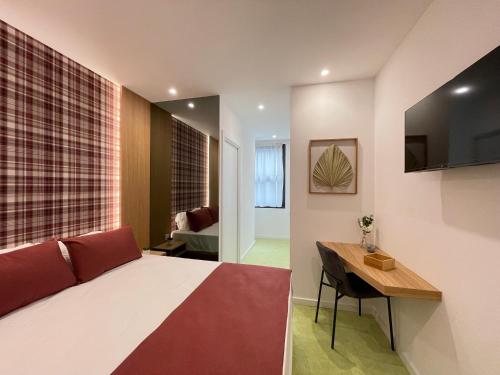 Dormitorio con cama, escritorio y TV en MyStay Porto São Bento, en Oporto