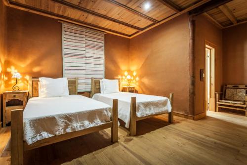 1 dormitorio con 2 camas y ventana en Casal da Serra, en Penha Garcia