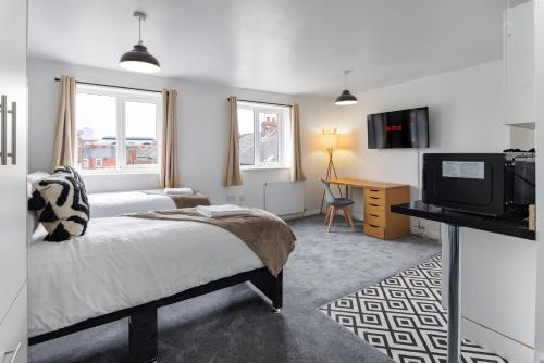1 dormitorio con 1 cama, TV y escritorio en City Centre Studio 9 with Kitchenette, Free Wifi and Smart TV with Netflix by Yoko Property en Middlesbrough