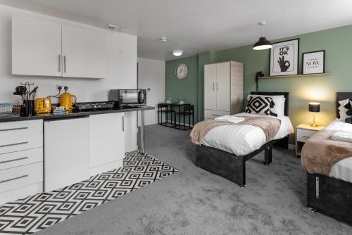 a kitchen and a bedroom with two beds and a counter at City Centre Studio 9 with Kitchenette, Free Wifi and Smart TV with Netflix by Yoko Property in Middlesbrough