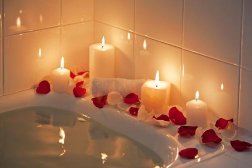 a bathroom with candles and roses in a bath tub at El Crater in San Antonio