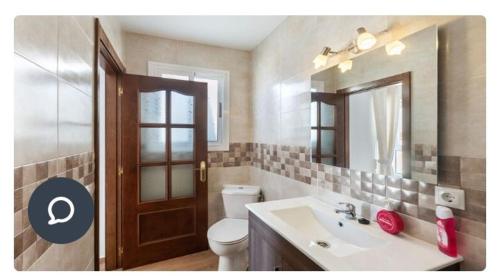 La salle de bains est pourvue d'un lavabo, de toilettes et d'un miroir. dans l'établissement Apartamento en Olvera, à Olvera