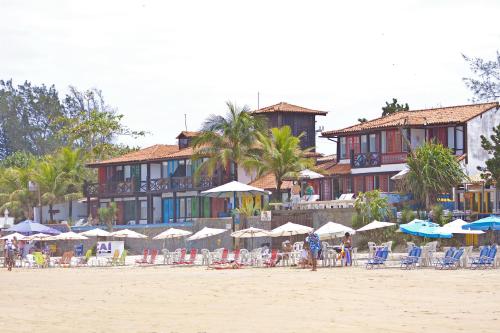 a group of chairs and umbrellas on a beach at Chez Pitu Praia Hotel in Búzios
