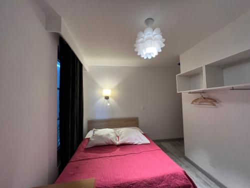 a bedroom with a bed with a pink blanket at Hôtel Belle Fontainebleau in Fontainebleau
