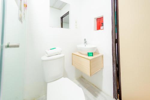 a bathroom with a white toilet and a sink at Ayenda Portal del Cable in Manizales
