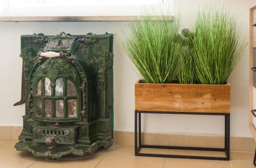 a green fireplace next to a table with two plants at Amazing view Bahai gardens - german colony center in Haifa
