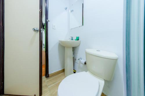 a bathroom with a toilet and a sink at Ayenda Portal del Cable in Manizales