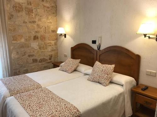 a bedroom with two beds with pillows on them at hostal Decerca Prádena in Prádena