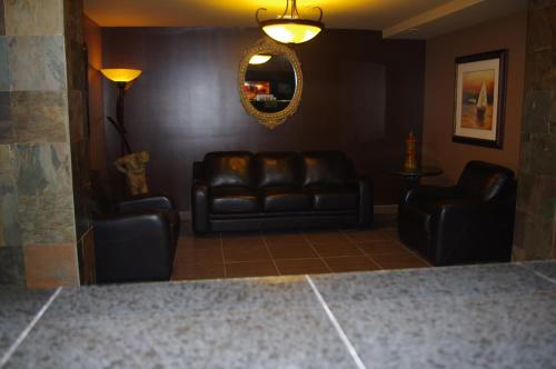 a living room with leather couches and a mirror at South Hill Lodge in Prince Albert