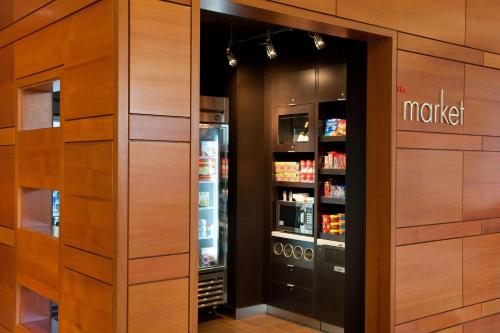 a walk in pantry with a refrigerator and a drink at Sonesta Emeryville San Francisco Bay Bridge in Emeryville