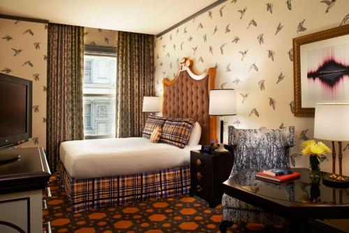 The Royal Sonesta Portland Downtown في بورتلاند: غرفة في الفندق مع سرير مع مضارب على الحائط