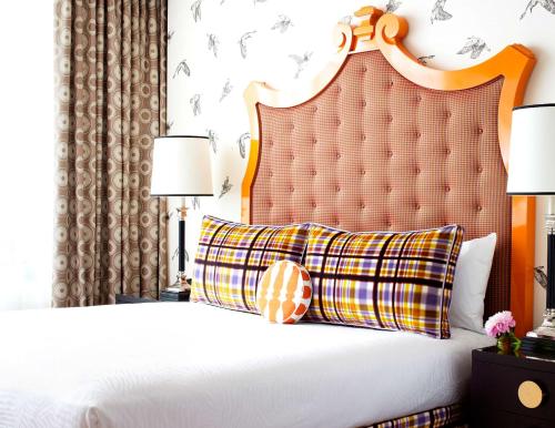 a bedroom with a white bed with a orange headboard at The Royal Sonesta Portland Downtown in Portland