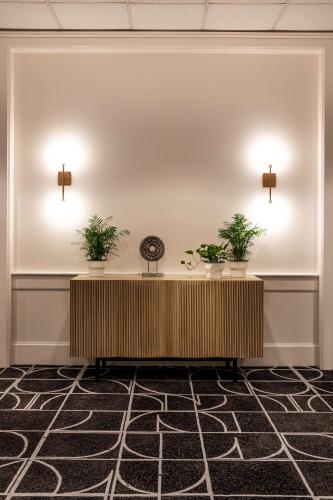 a reception desk in a lobby with two potted plants at The Royal Sonesta Portland Downtown in Portland