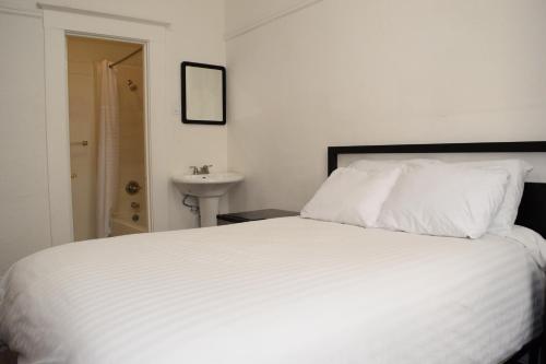 a bedroom with a white bed and a sink at Hotel Ikon in San Francisco