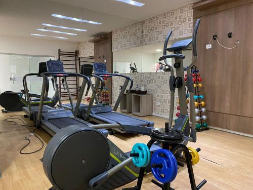 a gym with several treadmills and exercise bikes at Hotel Sabrina in Guanambi