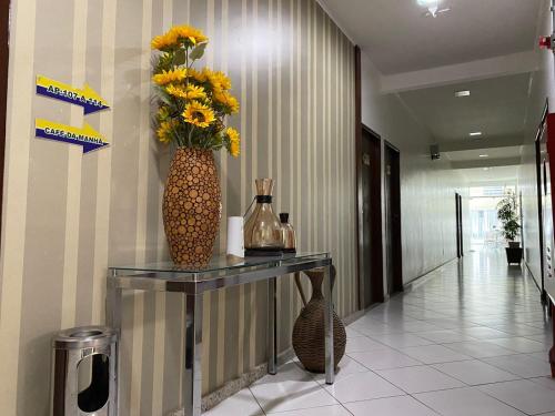 a vase with flowers on a table in a hallway at Hotel Sabrina in Guanamby