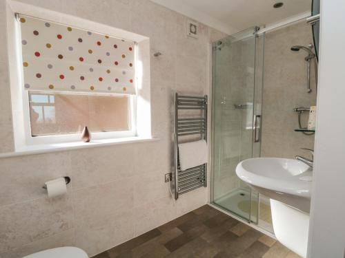 a bathroom with a shower and a sink and a window at Blakey in Liverton