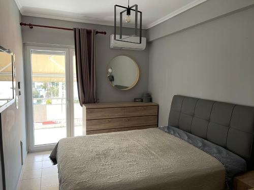 a bedroom with a bed and a mirror and a window at Adrianos House by the sea in Iraklitsa