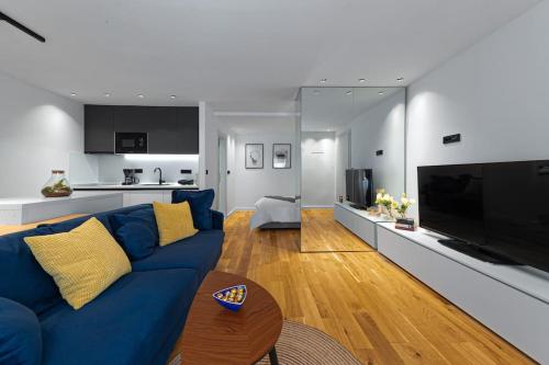a living room with a blue couch and a large television at Apartment Old Town Finesse in Dubrovnik