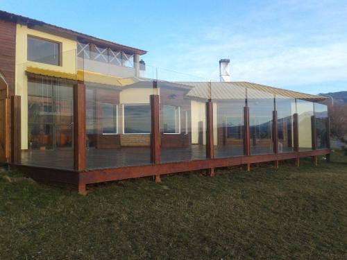 a house with glass windows and a roof at Hotel Picos Del Sur in El Calafate