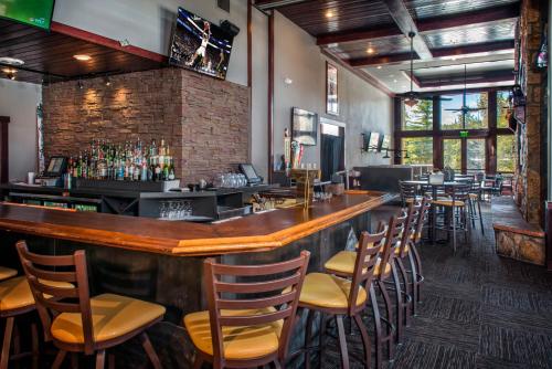 a bar in a restaurant with a bunch of chairs at Grand Timber Lodge in Breckenridge