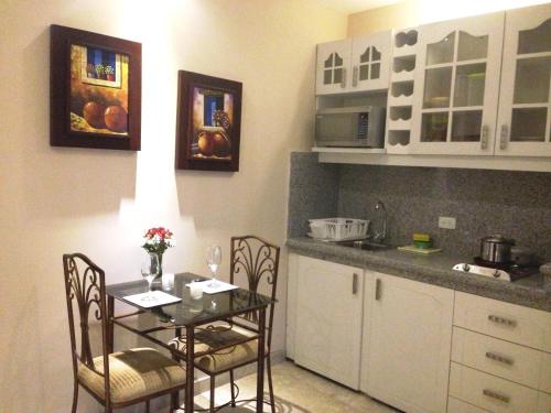 a kitchen with a table and chairs in a kitchen at El Patio Suites II in Guayaquil