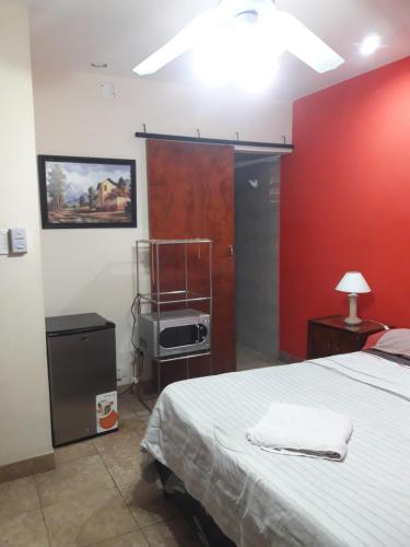 a bedroom with a bed and a red wall at Habitaciones BRISA in Salta