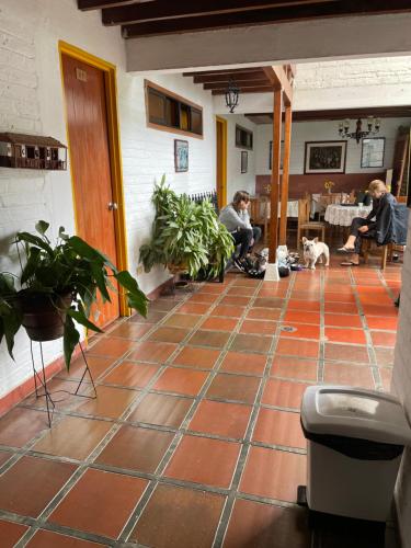a room with a tile floor with people and a dog at Hotel Alcarraza in Calima