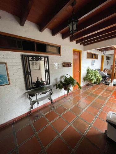 a living room with a tile floor and a mirror at Hotel Alcarraza in Calima