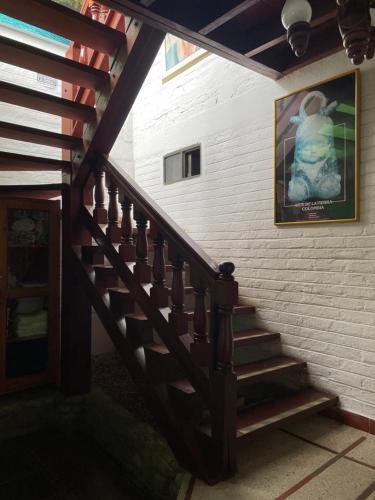 a wooden staircase in a building with a picture on the wall at Hotel Alcarraza in Calima