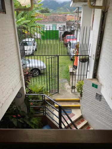 a stairway with a gate with cars in a parking lot at Hotel Alcarraza in Calima