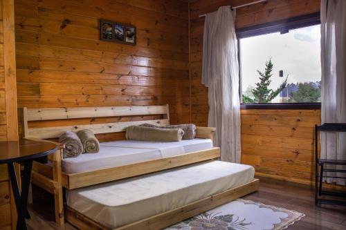 a bedroom with two beds in a log cabin at Cânions de Cambará in Cambará