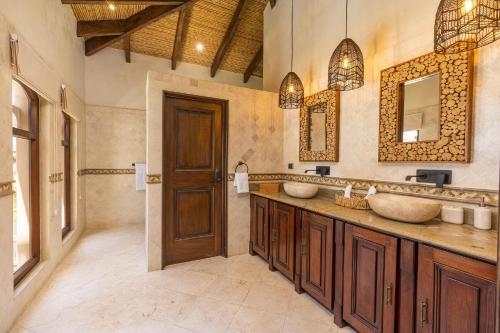 a bathroom with two sinks and two mirrors at Extravagant Beachfront Mansion in Flamingo, Second to None in Playa Flamingo
