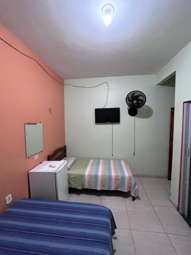 a bedroom with a bed and a flat screen tv at Hotel Toraryca in Belém