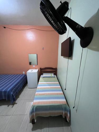 a room with a bed and a tv on a wall at Hotel Toraryca in Belém
