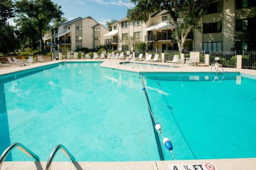 a large blue swimming pool with chairs and condos at Springwood Villas II in Hilton Head Island