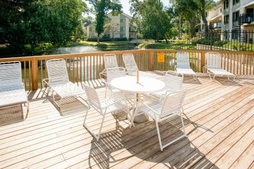 um grupo de cadeiras e uma mesa num deque em Springwood Villas II em Hilton Head Island