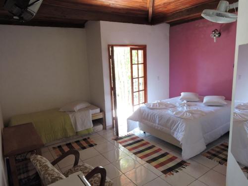 a bedroom with a large bed and a window at Pousada Vista Verde in Cunha