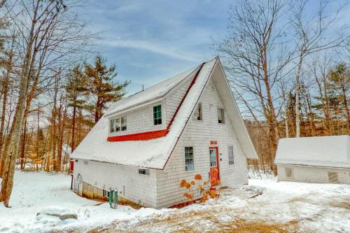 a white barn with a red door in the snow at Mullen Chalet in Greenwood