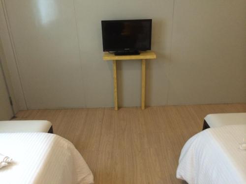 um quarto com uma televisão numa pequena mesa com duas camas em Shore Time Hotel - Annex em Boracay