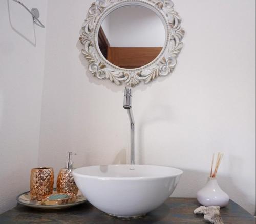 a bathroom with a white bowl and a mirror at Casa dos Sonhos in Ibicoara