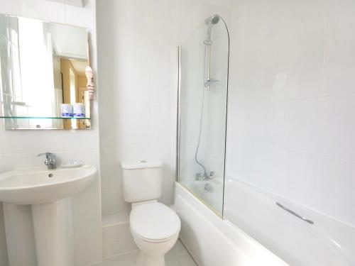 ein weißes Badezimmer mit Toilette und Waschbecken in der Unterkunft Mariner's Rest in Weymouth