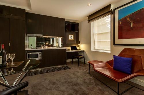 uma cozinha e sala de estar com um sofá e uma mesa em Quest East Melbourne em Melbourne
