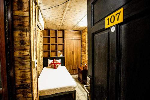 a small room with a bed and a sign on the door at Ha Giang Creekside Lodging and Tours in Ha Giang