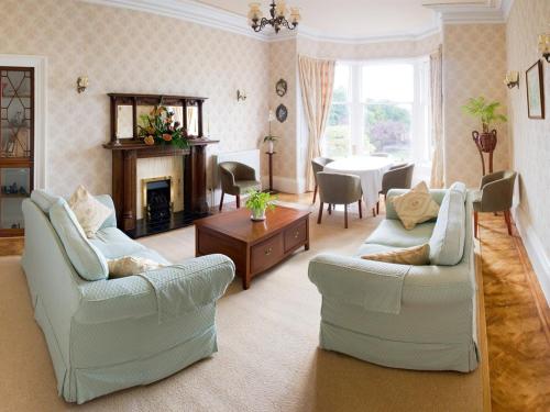 a living room with two couches and a dining room at Hartfell Guest House in Moffat