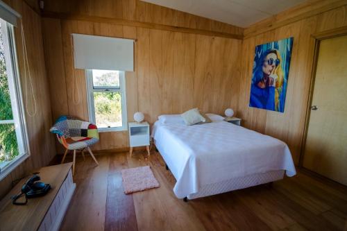 a bedroom with a bed and a painting on the wall at Salvaje Punta in Nueva Palmira